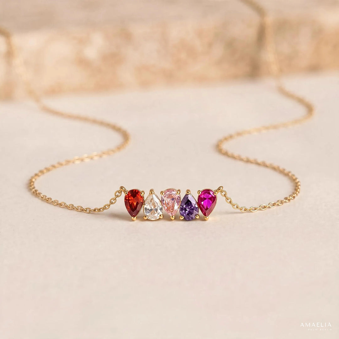 ROSALIE necklace with four birthstones on a soft beige background