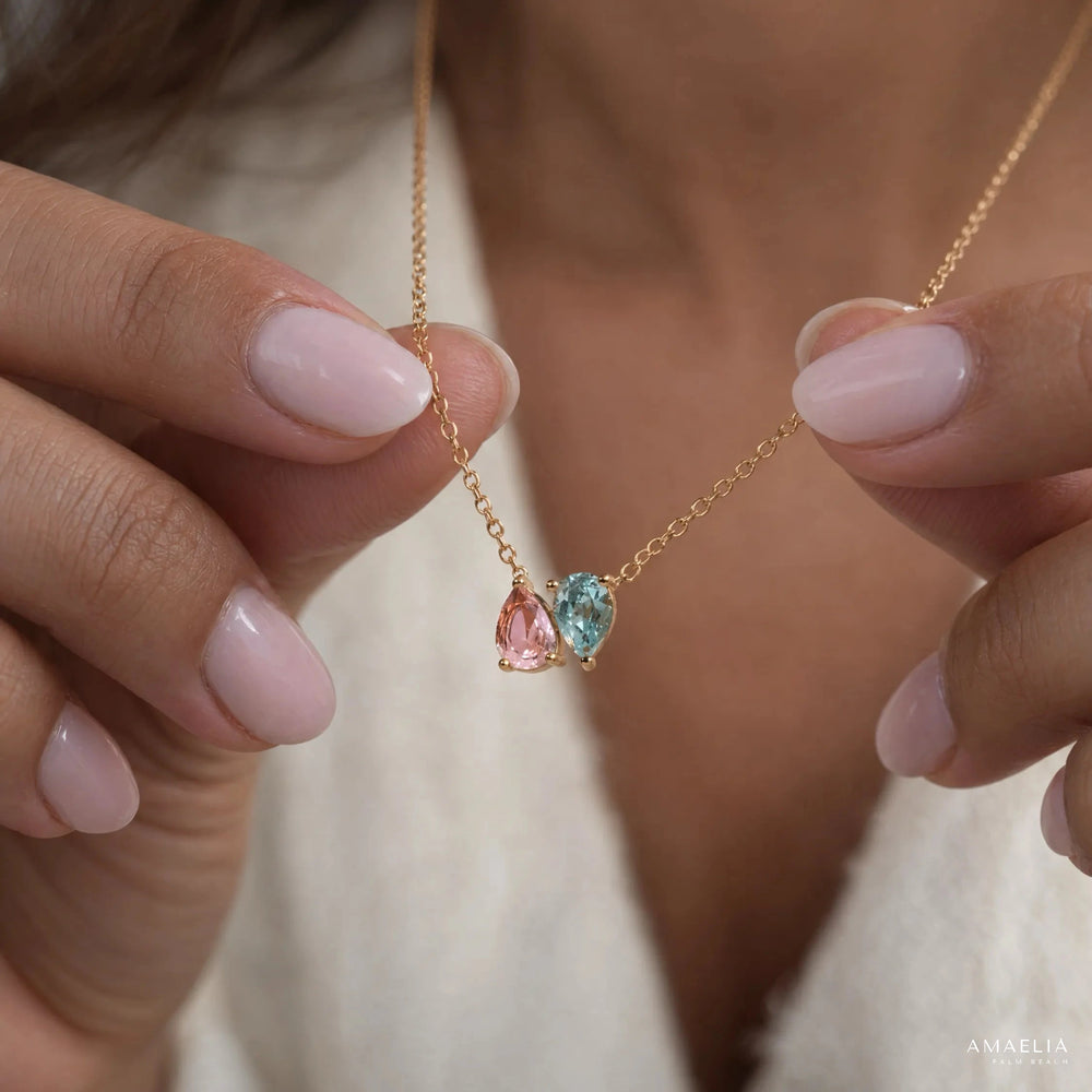 ROSALIE necklace with two birthstones, held between two fingers